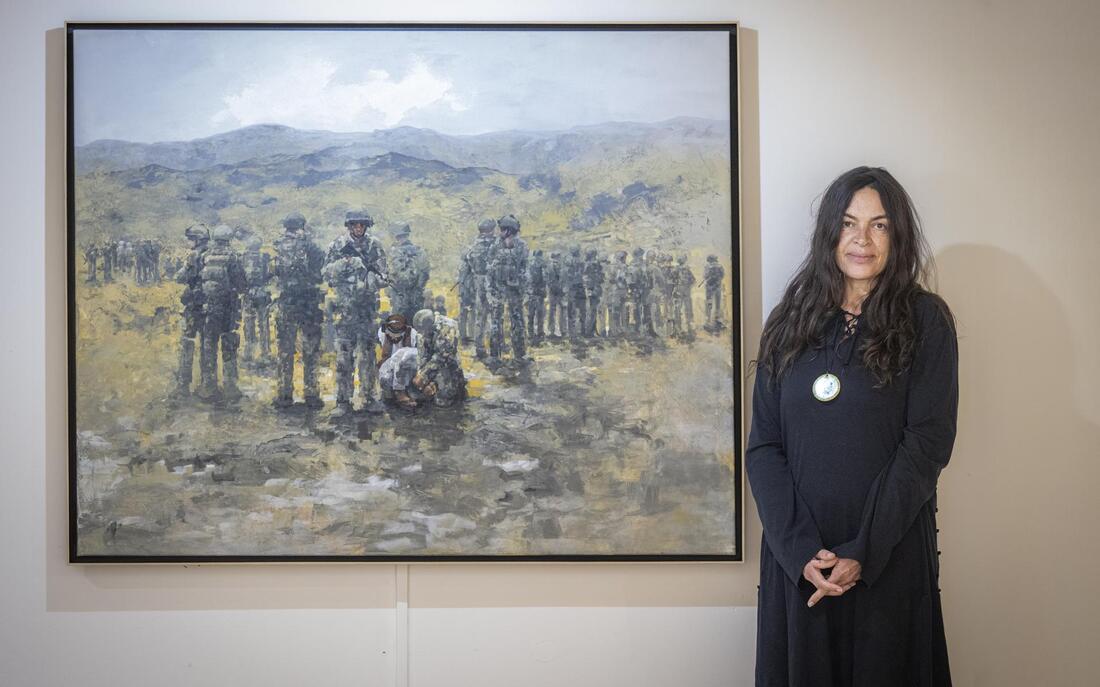 Kunstenares Roxanne Monsanto bij haar schilderij over de aanhouding van Talibanstrijders na de dood van Marc Harders en Jeroen Houweling. Foto: Marcel Jurian de Jong